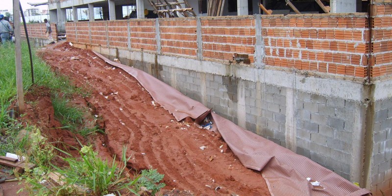 Qual é a melhor maneira de aplicar argamassa em um muro de contenção de  pedra antigo?